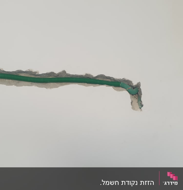 צינור ירוק עם חוטי חשמל בקיר חשוף